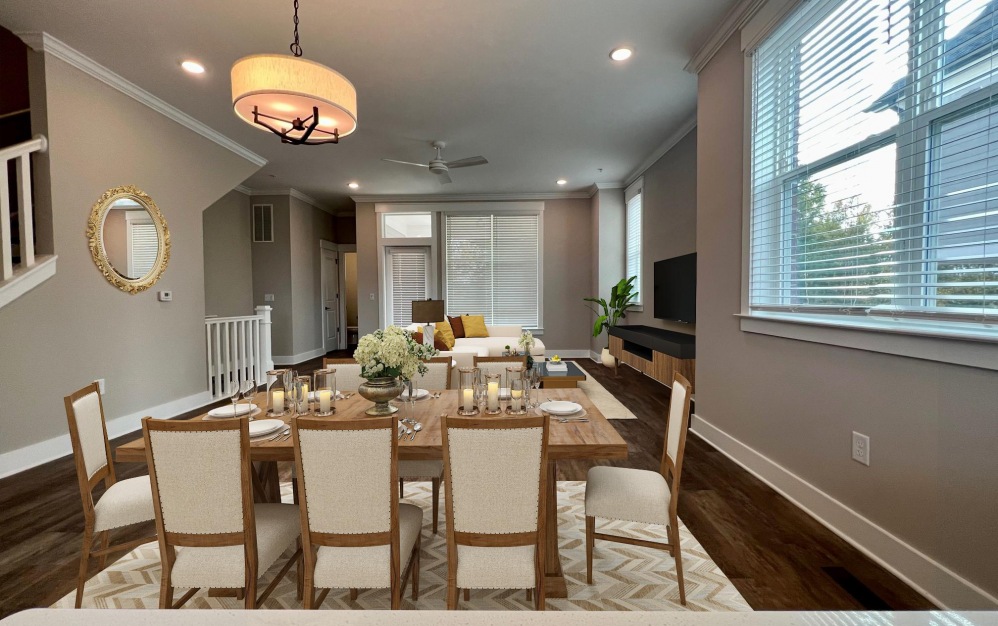 Dining area with large table and many chairs - large window welcoming natural sunlight