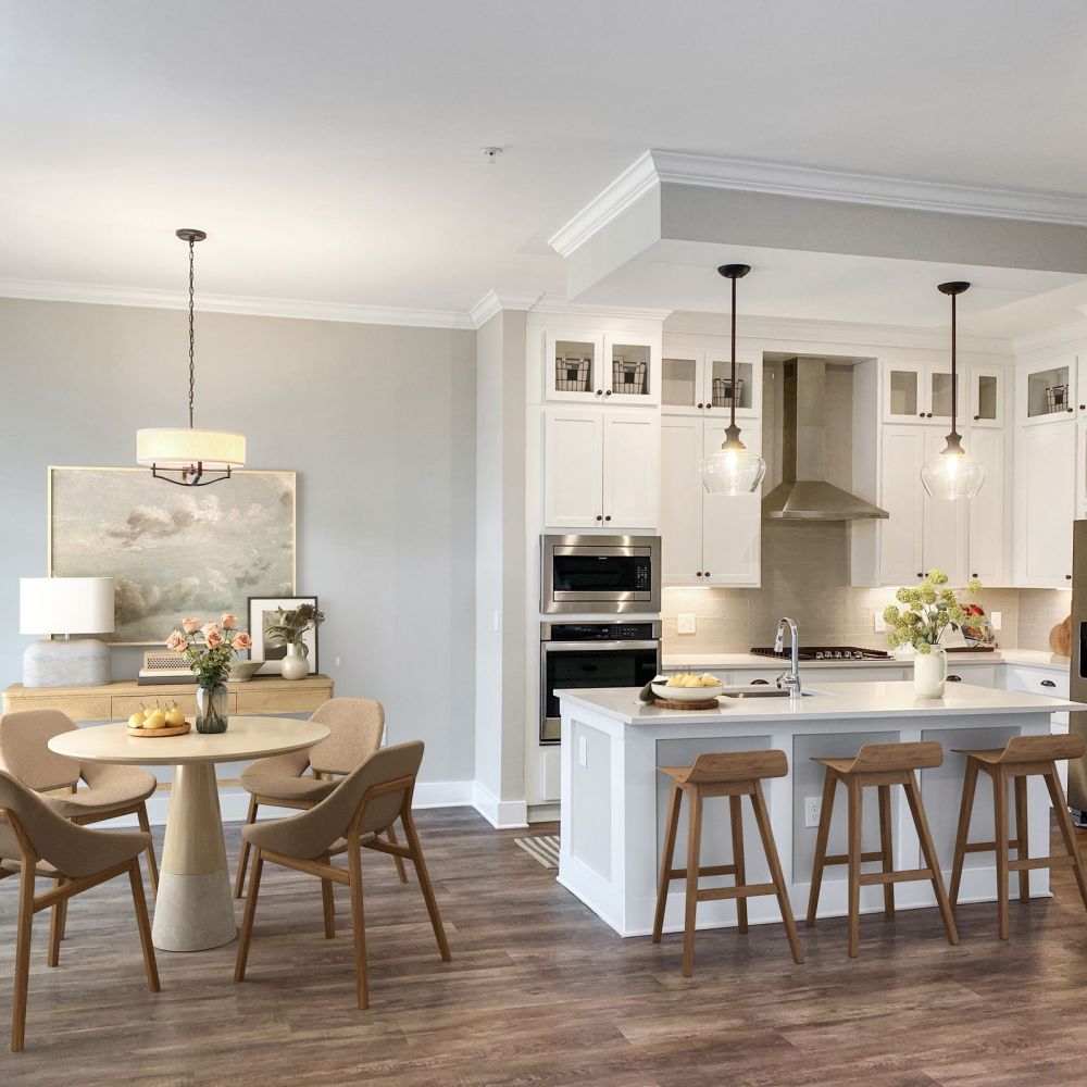 Townhomes at Bridlestone home interior open floor plan with large luxury kitchen and dining area furnished with tables, chairs, stools, and beautiful finishes