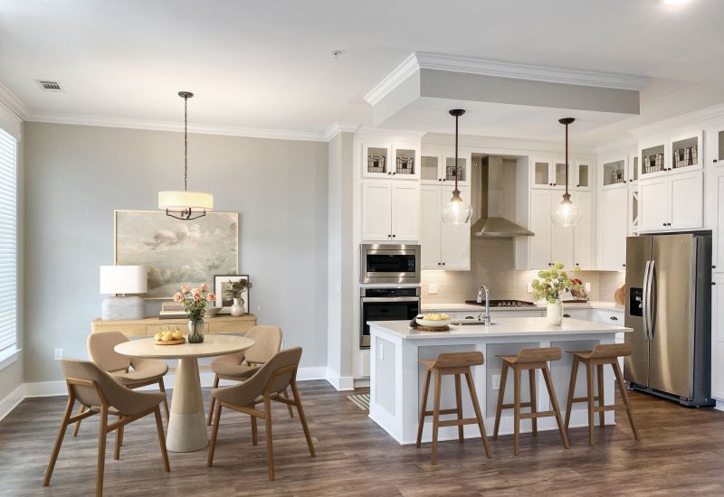 Townhomes at Bridlestone home interior open floor plan with large luxury kitchen and dining area furnished with tables, chairs, stools, and beautiful finishes