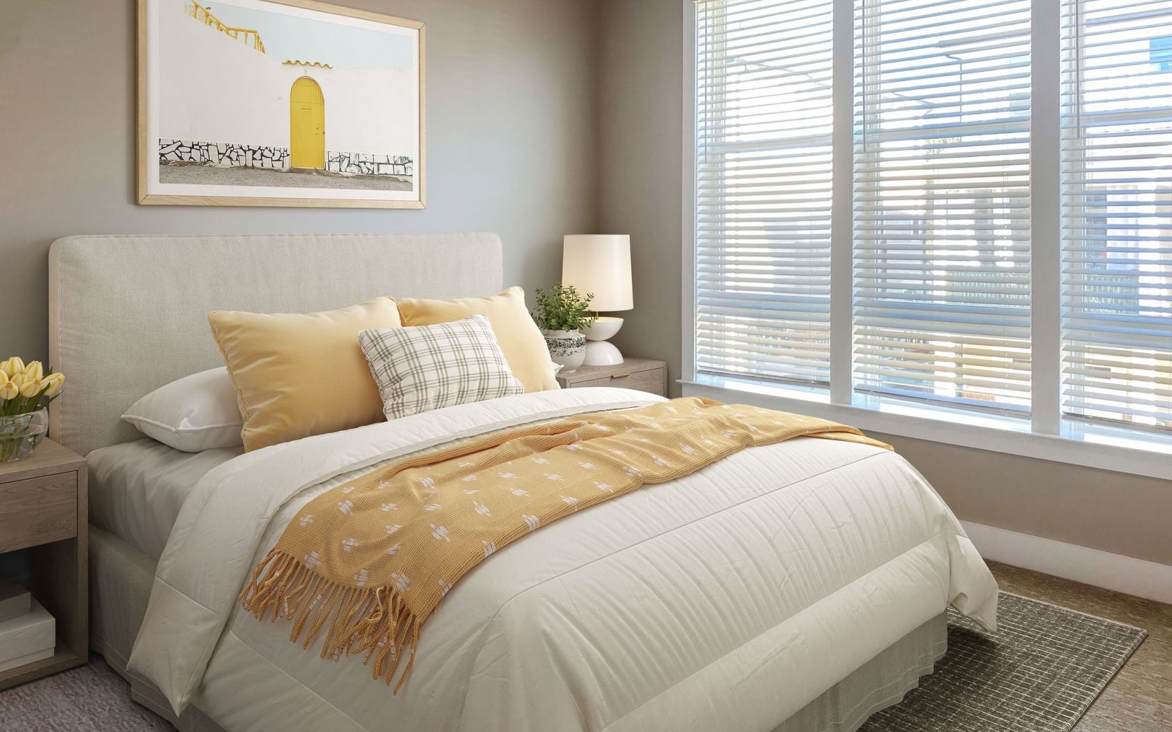 The Townhomes at Bridlestone bedroom with large windows, furnished with bed and nightstands