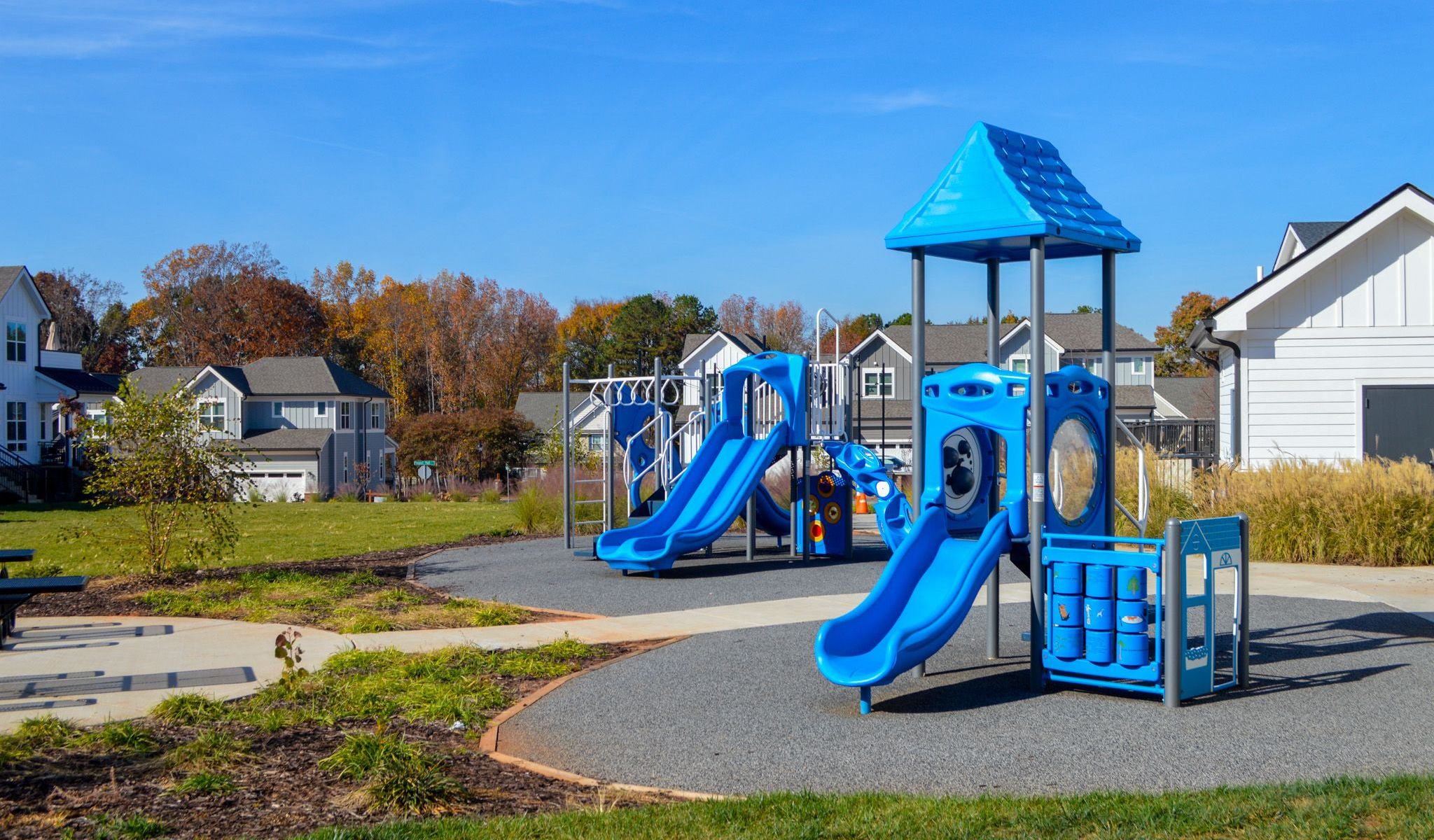 Townhomes at Bridlestone blue community playground surrounded by grass area