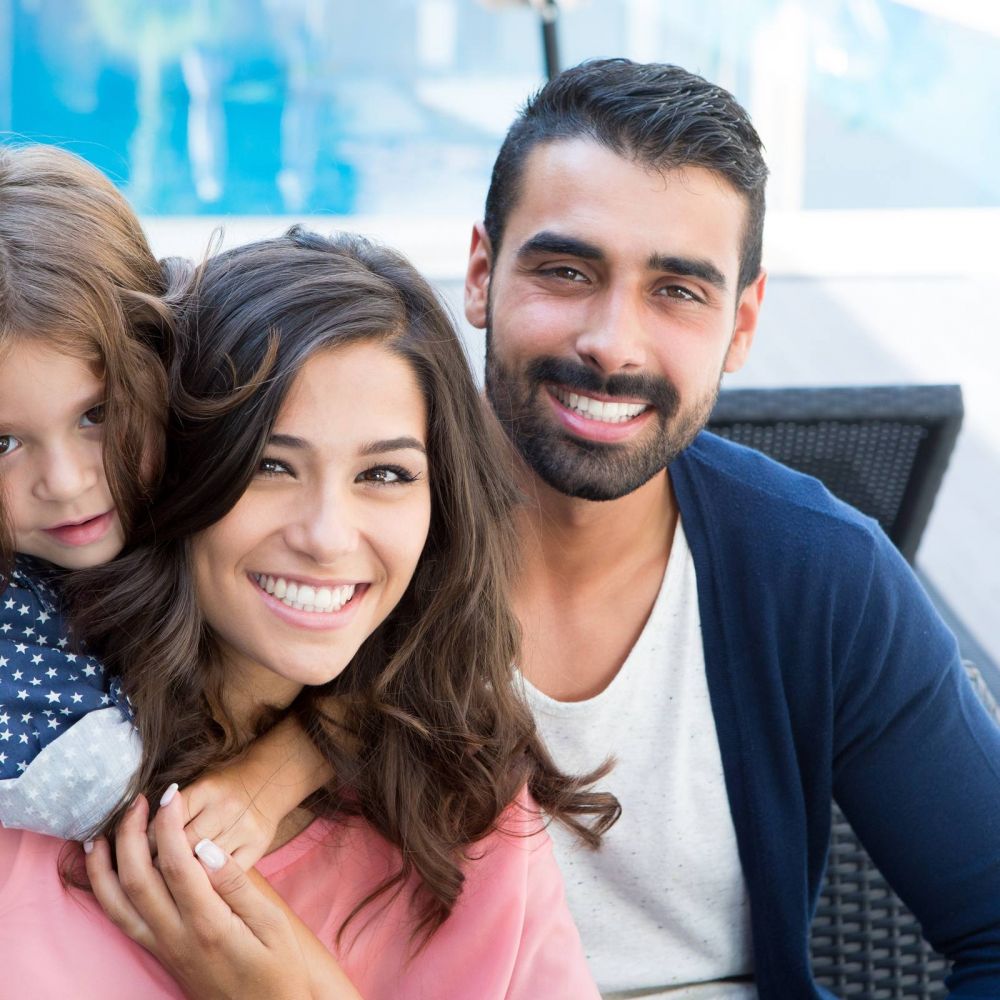 Beautiful family smiling and relaxing close to a a pool