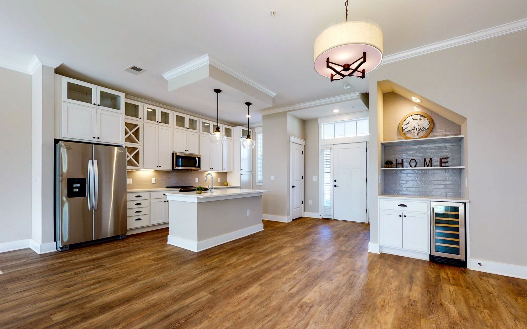 The Townhomes at Bridlestone kitchen and living room with open floor plan featuring wood floors, high ceilings, and beautiful finishes